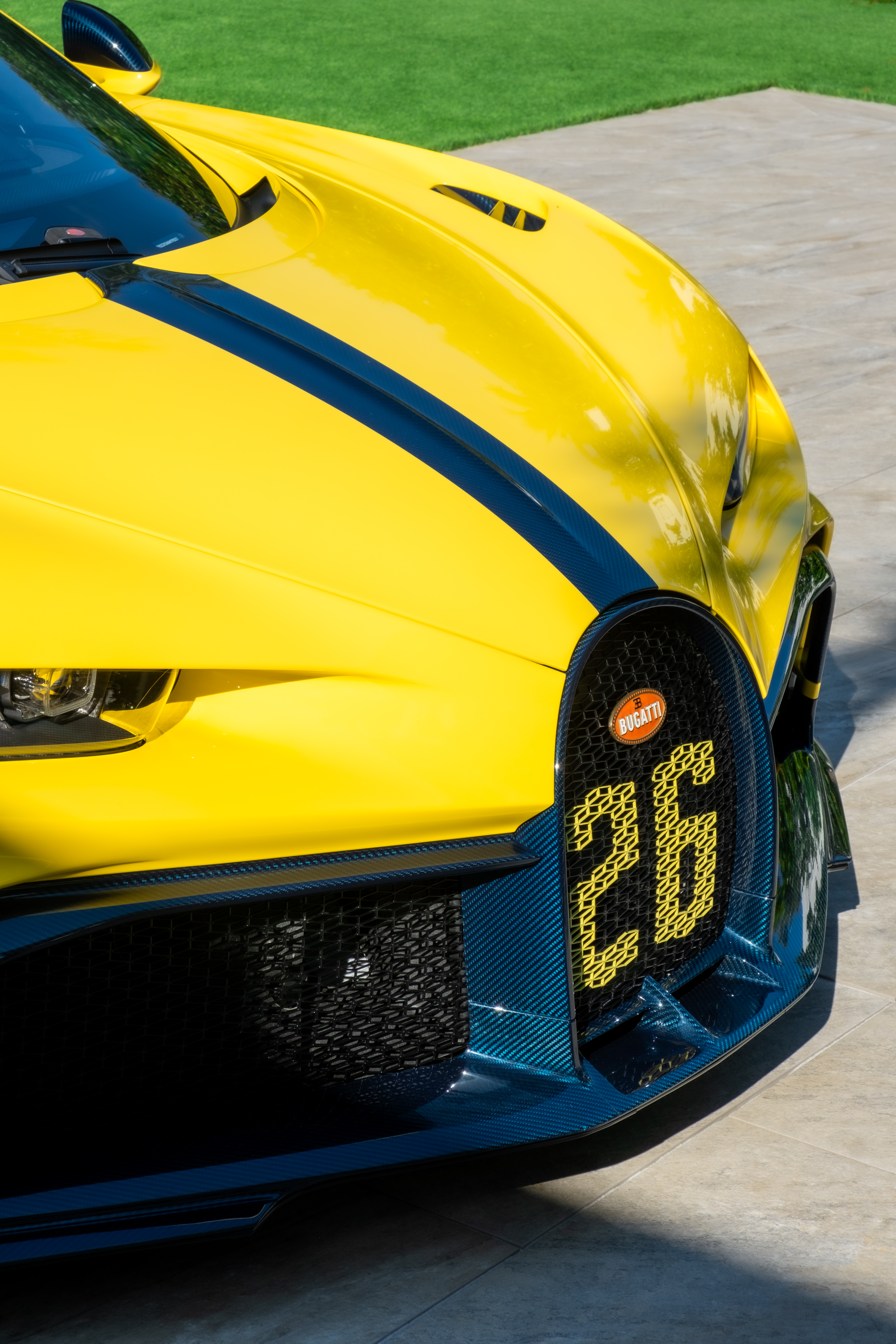 “Ferrari logo close-up on carbon fiber hood during luxury automotive photo session.”